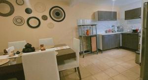 a kitchen with a table and white chairs and a table and a kitchen at Casa Amapolas Oaxaca in Oaxaca City