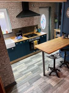 cocina con armarios azules y mesa de madera en Jackson place, en Newton Aycliffe