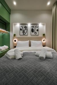 una camera da letto con un grande letto con quattro cuscini di Plane Tree Luxury Suites a Ioannina
