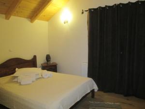 a bedroom with a bed with a black curtain at Pension Cabana Ionela in Vama