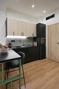 a kitchen with black and white cabinets and a table at Plane Tree Luxury Suites in Ioannina