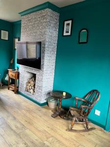 sala de estar con chimenea, silla y TV en Jackson place en Newton Aycliffe