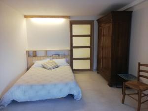 een slaapkamer met een bed en een houten kast bij Appartement 40m2 avec terrasse et vue superbe in Theys