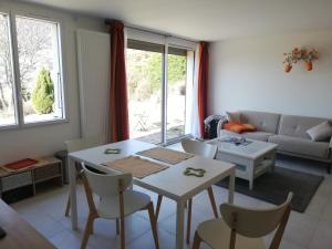 een woonkamer met een tafel en stoelen en een bank bij Appartement 40m2 avec terrasse et vue superbe in Theys