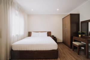 Schlafzimmer mit einem Bett, einer Kommode und einem Spiegel in der Unterkunft Song Hưng Hotel & Serviced Apartments - Căn hộ Dịch vụ & Khách sạn in Ho-Chi-Minh-Stadt