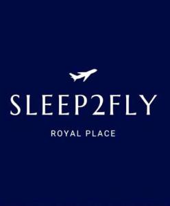 Sleep2Fly Hamburg-Airport في هامبورغ: طائرة بيضاء تطير في السماء مع خلفية زرقاء