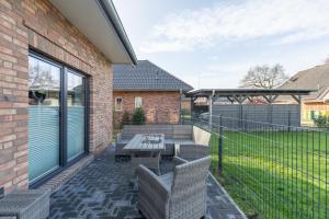 a patio with a table and chairs and a fence at Hooge in Hattstedt