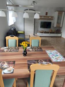 a dining room table with chairs and a living room at Ferienwohnung am Olbasee in Malschwitz