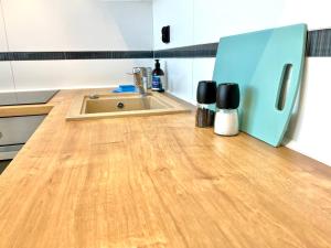 cocina con fregadero y suelo de madera en Apartament Aviator en Mielec