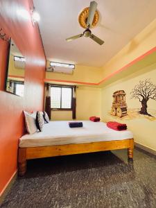 a bedroom with a bed with a ceiling fan at VAIBHAV HOME STAY in Hampi