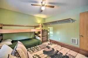 a bedroom with a bunk bed and a ceiling fan at Wooded Danbury Cabin with Grill and Fire Pit! in Danbury