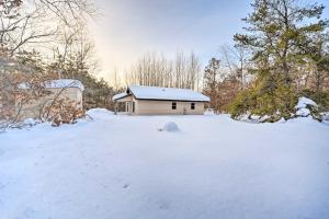 a small house in a snow covered yard at Wooded Danbury Cabin with Grill and Fire Pit! in Danbury