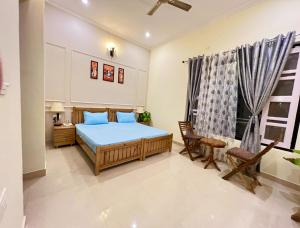 RAMSHILA COTTAGE في Bhowāli: غرفة نوم بسرير وكراسي ونافذة