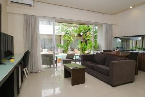 a living room with a couch and a table at Sunset Mansion Seminyak in Seminyak