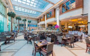 a restaurant with tables and chairs in a building at Empark Grand Hotel Kunming in Kunming