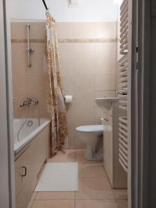 een badkamer met een bad, een toilet en een wastafel bij Klimatyczne mieszkanie w doskonałej lokalizacji in Warschau