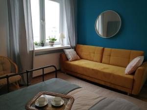 a living room with a couch and a mirror at Klimatyczne mieszkanie w doskonałej lokalizacji in Warsaw