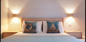 ein Schlafzimmer mit einem Bett mit Kissen darauf in der Unterkunft Deluxe Apartment near the Airport Adults Only in Porto Rafti