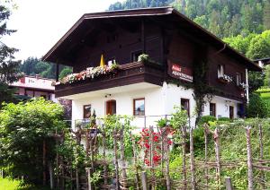 a building with flowers in front of a fence at Haus Abendsonne in Reit im Winkl