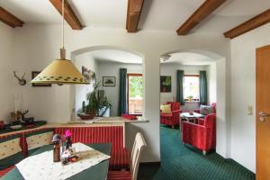 eine Küche und ein Wohnzimmer mit einem Tisch und roten Stühlen in der Unterkunft Haus Abendsonne in Reit im Winkl