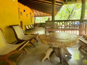 einen großen Holztisch und Stühle in einem Zimmer in der Unterkunft Eth Mansala in Sigiriya