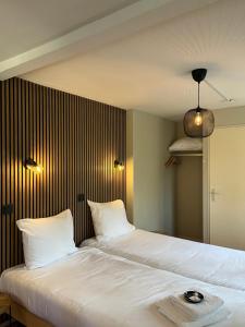 a bedroom with a large bed with white sheets at Hotel De Barones in Dalfsen