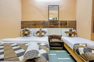 een slaapkamer met 2 bedden en een spiegel bij Terminus Hotel Bandra in Mumbai