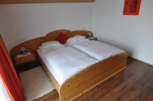 マリアプファルにあるHaus Schreilechnerの木製ベッド(白いシーツ、枕付)が備わるベッドルームです。