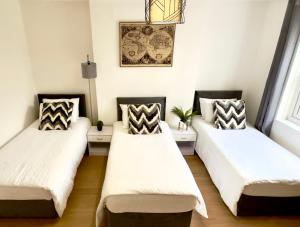 3 posti letto in una stanza con pareti bianche di Beautiful 3-Bed Apartment with Driveway Parking a Nottingham