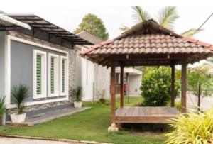 a wooden gazebo in front of a house at FRA Homestay in Kuantan