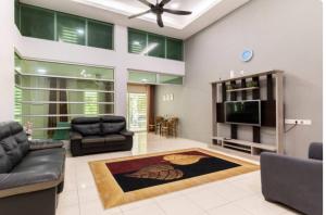 a living room with a couch and a television at FRA Homestay in Kuantan