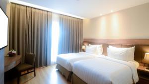 Un pat sau paturi într-o cameră la The Excelton Hotel