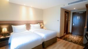 Un pat sau paturi într-o cameră la The Excelton Hotel