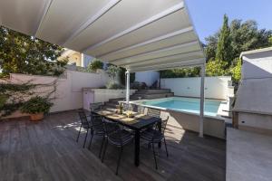a patio with a table and chairs and a pool at Villa Karmen Adriatica in Kukljica