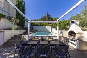 a patio with a table and chairs and a swimming pool at Villa Karmen Adriatica in Kukljica