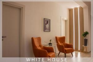 - deux chaises orange dans une chambre avec une maison blanche dans l'établissement White House, à Tbilissi