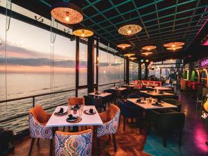 a restaurant with tables and chairs and a view of the water at The Ocean Colombo in Colombo