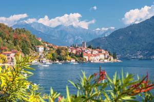 une ville sur la rive d'un lac avec des montagnes dans l'établissement Cinzia Apartment Front Beach - Happy Rentals, à Sirmione