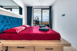 ein Schlafzimmer mit einem roten Bett mit einem großen Fenster in der Unterkunft Walking distance old town 120m2,garden,view,garage in Dubrovnik