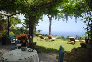 um pátio com cadeiras e uma mesa com vista em Hotel Sant'Andrea em Marciana