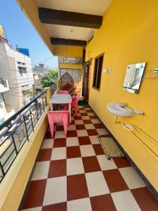 a balcony with a table and chairs and a checkered floor at VAIBHAV HOME STAY in Hampi