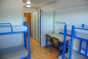 a room with two bunk beds and a table and chairs at Alberg L'Escala Xanascat in L'Escala +36 photos