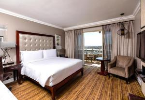a hotel room with a bed and a chair at InterContinental Johannesburg OR Tambo Airport Hotel by IHG in Kempton Park