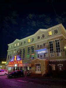 a large building with neon signs in front of it at ALCAZAR in Atyraū
