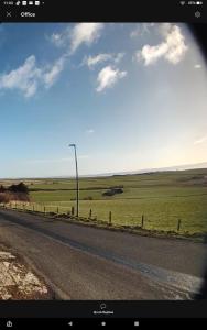 a road with a street light on the side of a field at Scorrabrae, Orphir, Mainland Orkney, Scotland, United Kingdom in Orphir