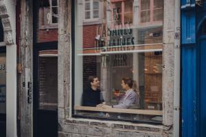 un hombre y una mujer sentados en una ventana en Cabane Urbaine 1 - centre en Namur