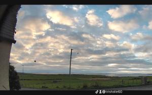 a cloudy sky with a pole in a field at Scorrabrae, Orphir, Mainland Orkney, Scotland, United Kingdom in Orphir