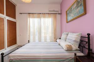 Bett in einem Zimmer mit Fenster in der Unterkunft Golden Seaside House number 2 in Eantio