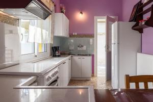 een keuken met witte apparatuur en paarse muren bij Golden Seaside House number 2 in Eantio +15 foto's