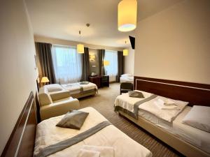 a hotel room with two beds and a chair at Hotel Szyndzielnia Eco in Bielsko-Biała